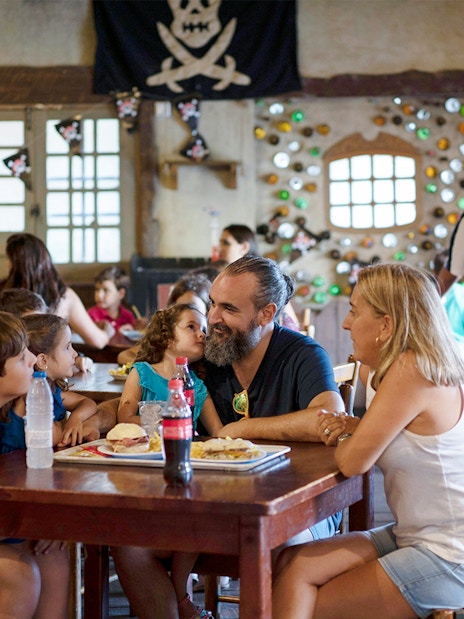 Family dining in pirate-themed restaurant at Isla Mágica, Seville.