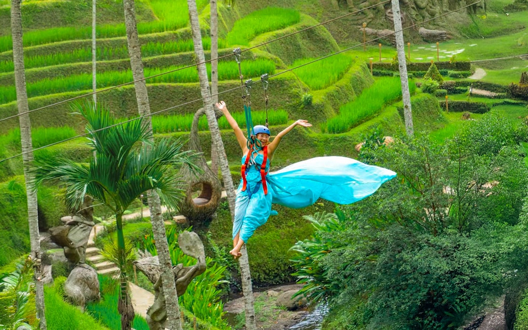 Lady ziplining over rice terraces at Alas Harum Bali.