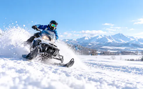 Snowmobile ride in snowy landscape with mountains, Sapporo, Hokkaido.