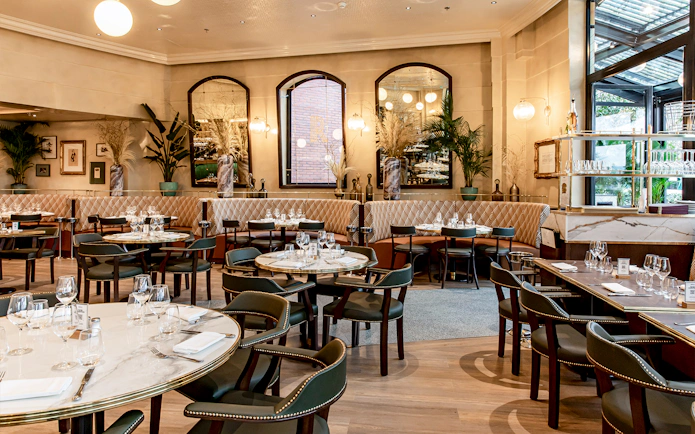 Brasserie Rosalie dining area set for breakfast with elegant decor and large windows.