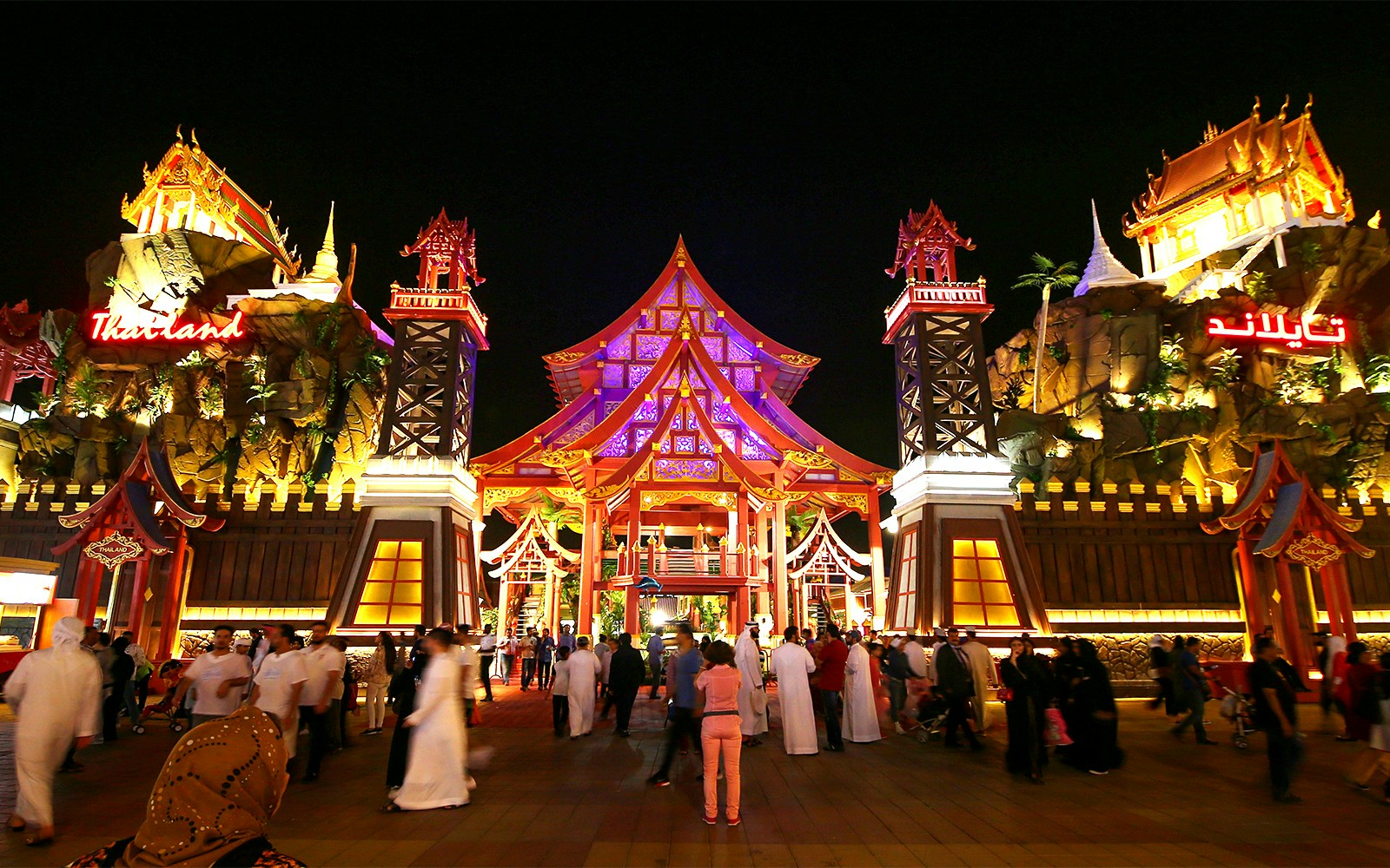Tourists walking through the illuminated Thailand pavilion at Global Village Dubai.