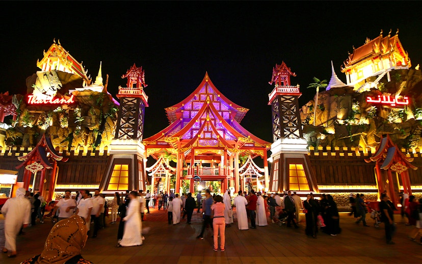 Tourists walking through the illuminated Thailand pavilion at Global Village Dubai.