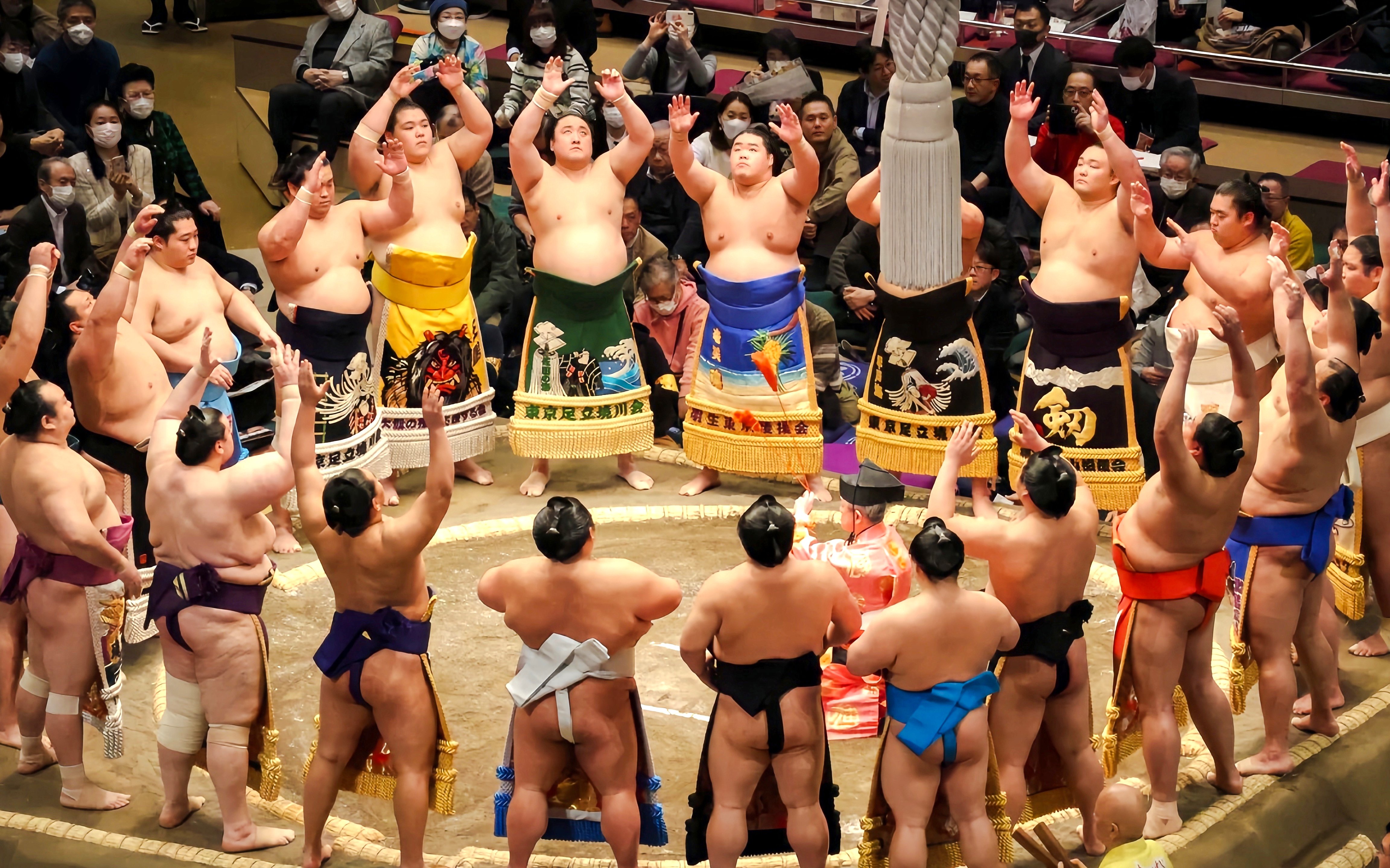 Sumo wrestlers performing pre-match ritual in a Tokyo ring.