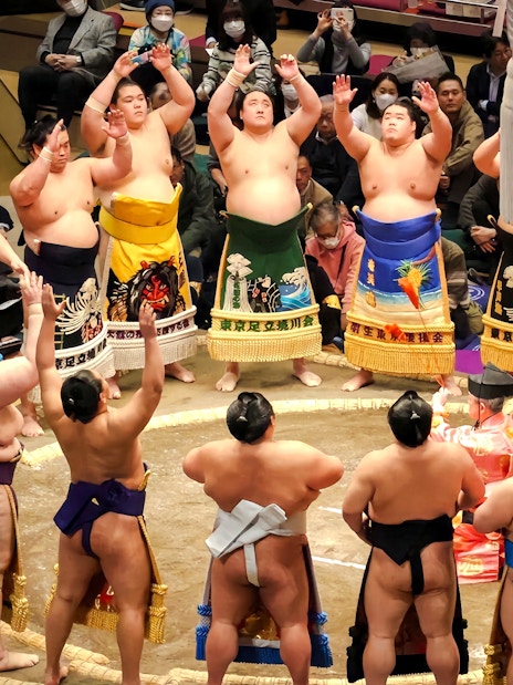 Sumo wrestlers performing pre-match ritual in a Tokyo ring.