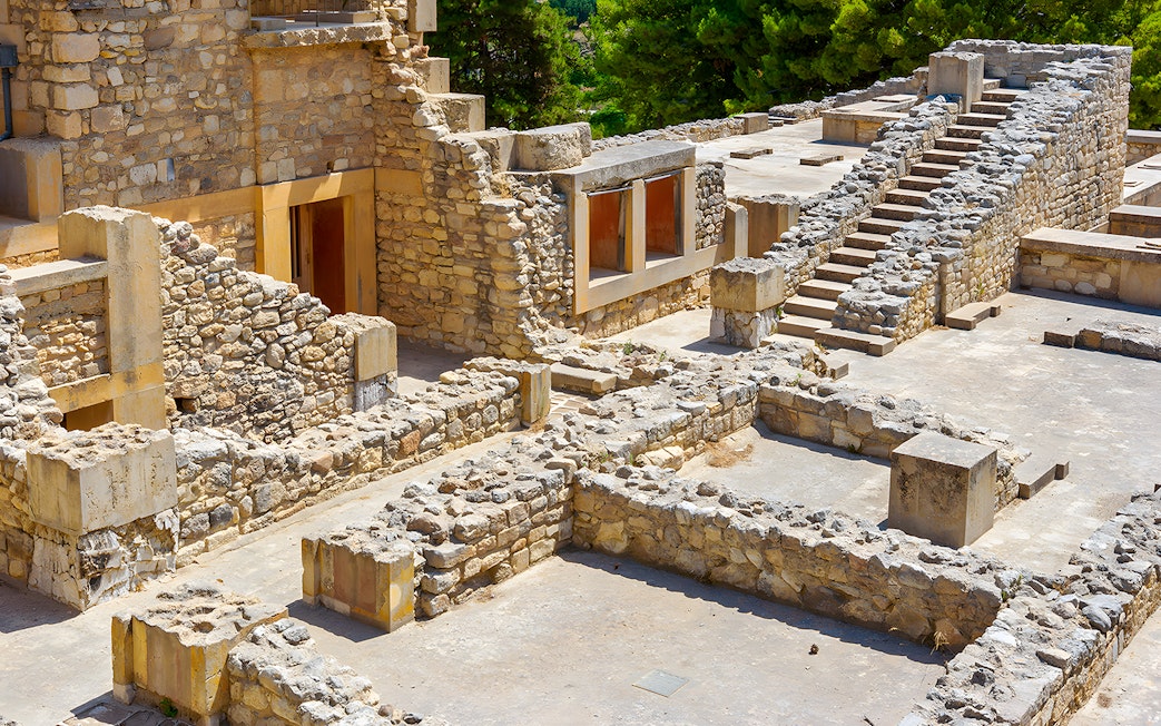 Knossos Palace ruins with stone rooms and stairs in Crete, Greece.