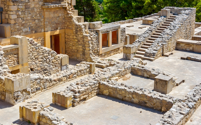 Knossos Palace ruins with stone rooms and stairs in Crete, Greece.