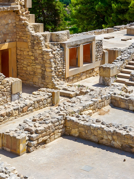 Knossos Palace ruins with stone rooms and stairs in Crete, Greece.