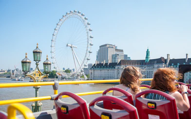Tootbus passing by the London Eye and River Thames on a Hop-On-Hop-Off tour.