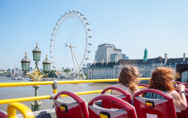 Tootbus passing by the London Eye and River Thames on a Hop-On-Hop-Off tour.
