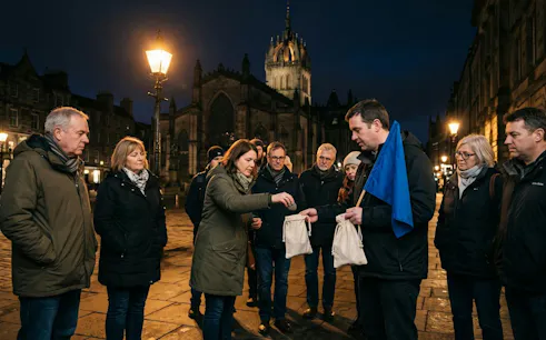 Participants on Edinburgh True Crime Walking Tour near St Giles' Cathedral at night.