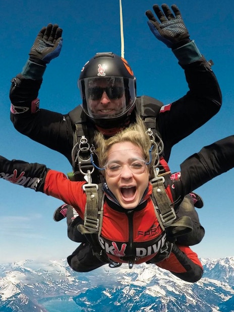 Skydiving tandem over snowy mountains in Interlaken, Switzerland.