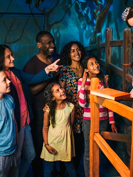 Group admiring Sleeping Beauty figure at a themed attraction.