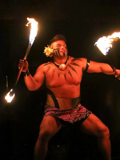 Fire dancer performing at Germaine's Luau with flaming torches.