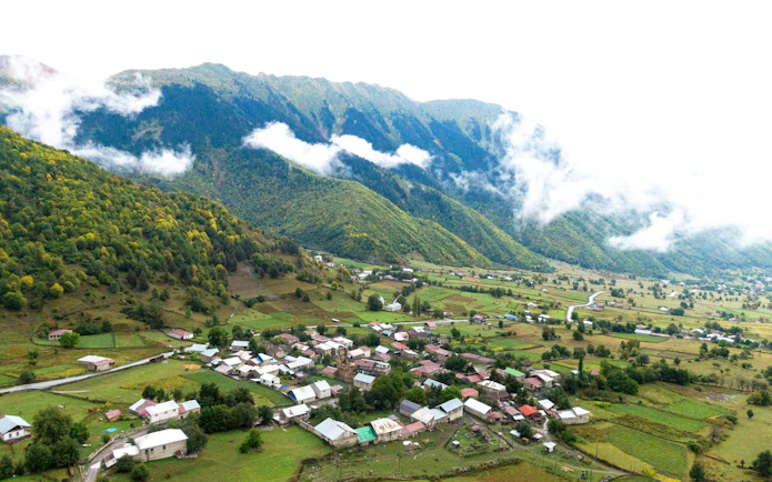 Aerial view of a village surrounded by lush mountains in Gabala, Azerbaijan.