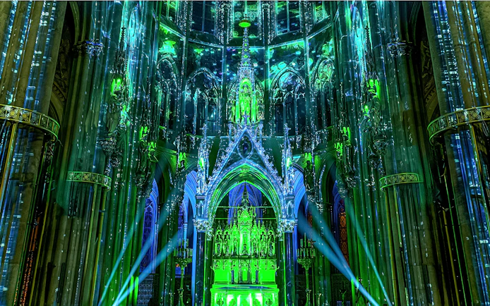Votivkirche interior illuminated with green and blue lights during Light of Creation event in Vienna.