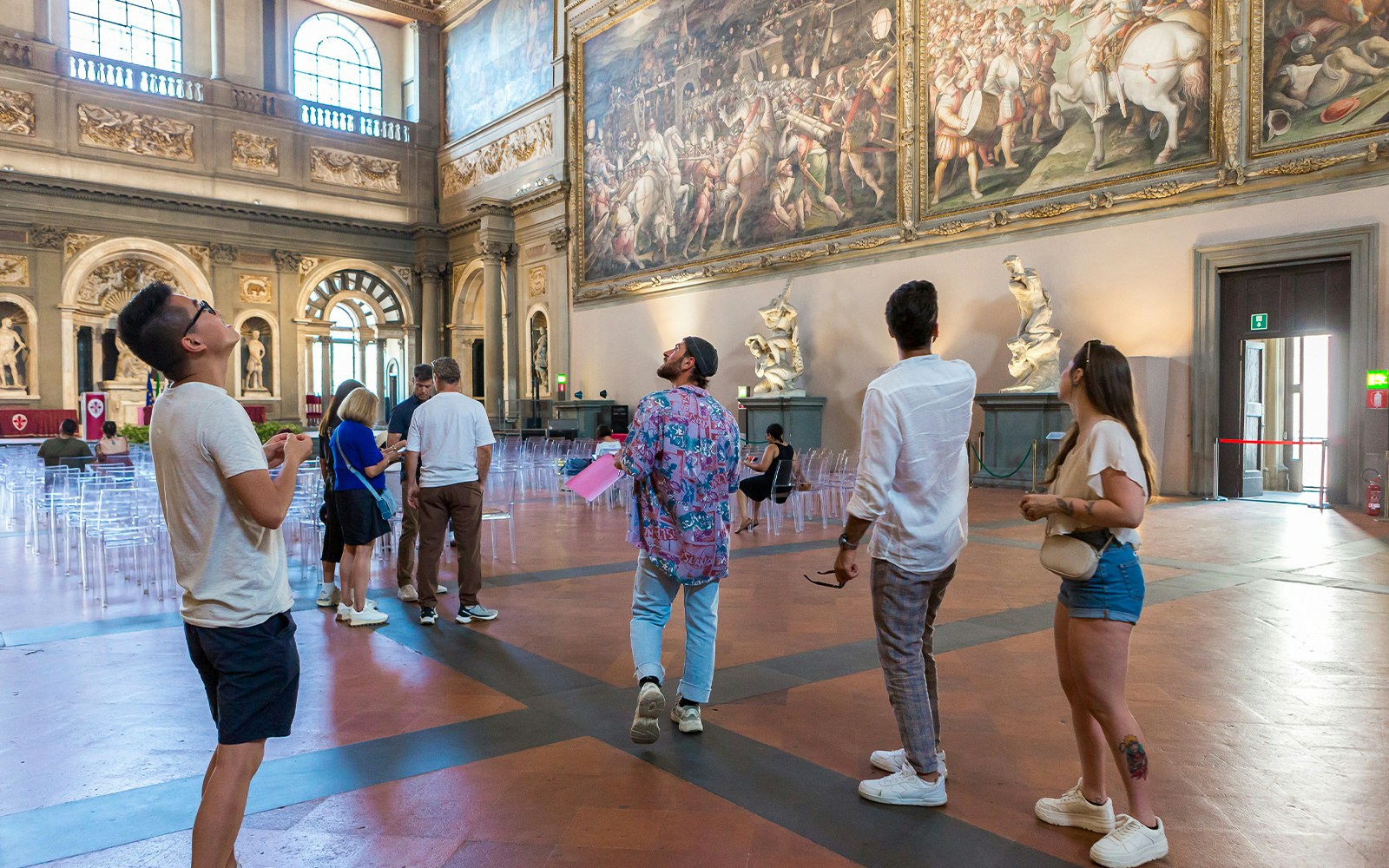 Visitors admiring frescoes inside Palazzo Vecchio, Florence.