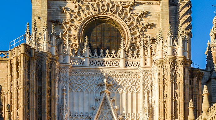 Seville Cathedral facade with intricate Gothic details and Giralda tower.