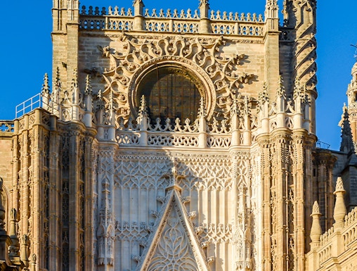 Seville Cathedral facade with intricate Gothic details and Giralda tower.