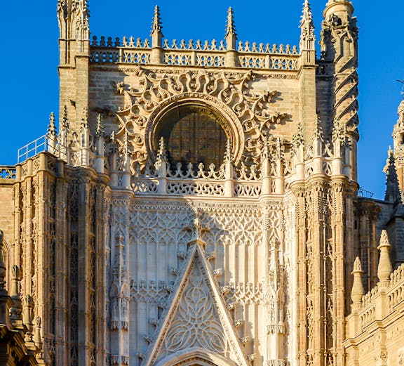 Seville Cathedral facade with intricate Gothic details and Giralda tower.