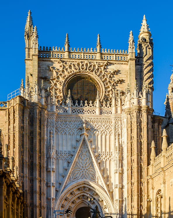 Seville Cathedral facade with intricate Gothic details and Giralda tower.