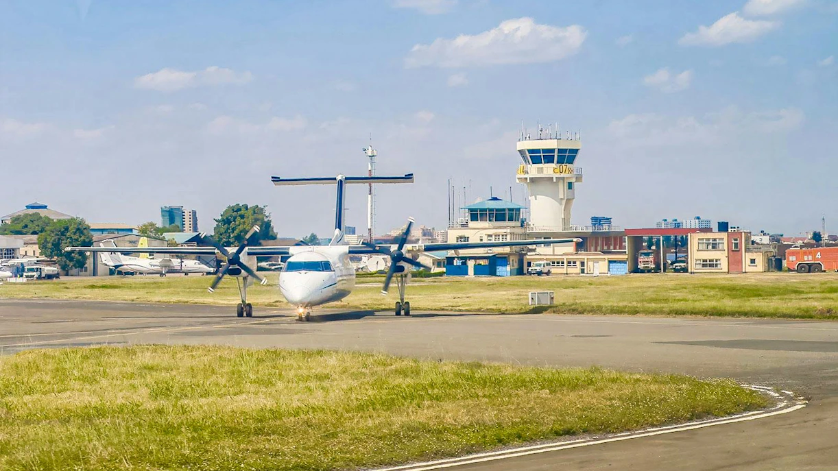 Propjet airplane on runway near control tower at Wilson Airport, Nairobi, Kenya.