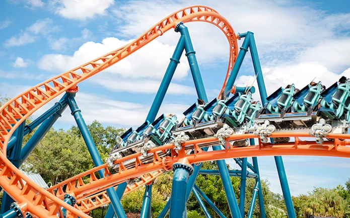 Roller coaster on Ice Breaker ride at SeaWorld Orlando with vibrant orange and blue tracks.