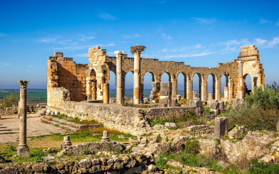 Basilica ruins with arches and columns in Volubilis, Morocco.