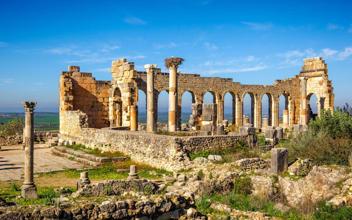 Basilica ruins with arches and columns in Volubilis, Morocco.