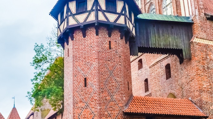 Malbork Castle brick tower with decorative patterns and Gothic architecture.