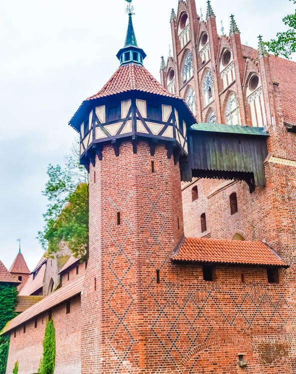 Malbork Castle brick tower with decorative patterns and Gothic architecture.