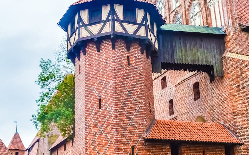 Malbork Castle brick tower with decorative patterns and Gothic architecture.