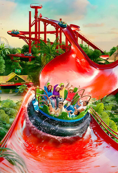 Visitors enjoying a water ride at Bellewaerde Park with vibrant red slides and lush greenery.