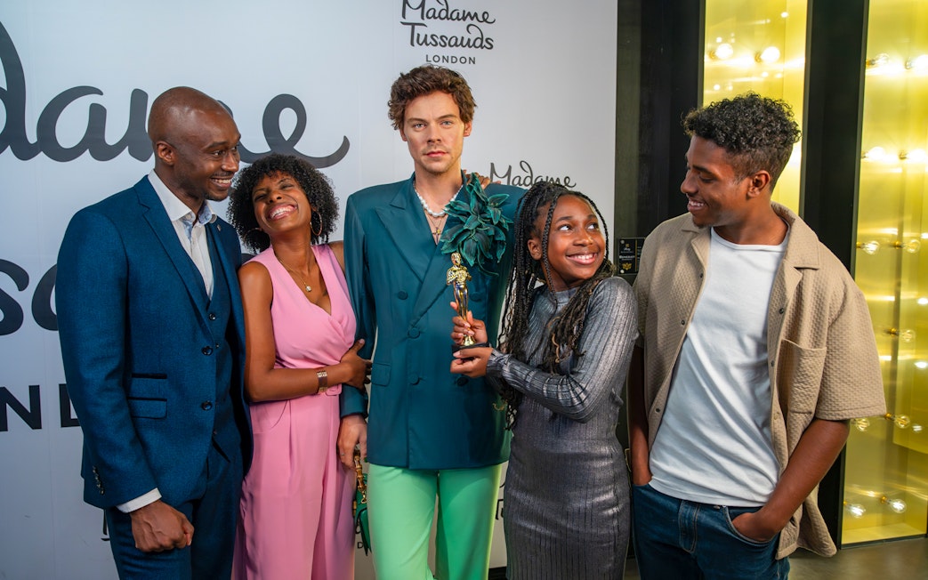 Visitors with Harry Styles wax figure at Madame Tussauds London.
