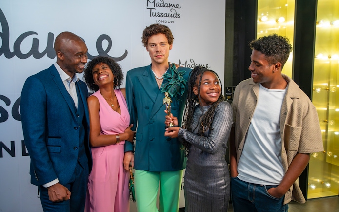 Visitors with Harry Styles wax figure at Madame Tussauds London.