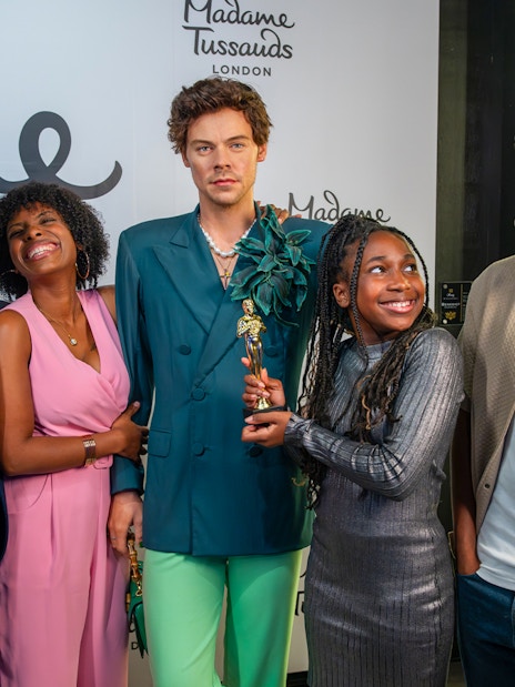 Visitors with Harry Styles wax figure at Madame Tussauds London.
