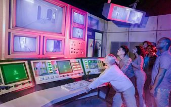 Guests interacting with control panels at Stranger Things games, Netflix House, Philadelphia.