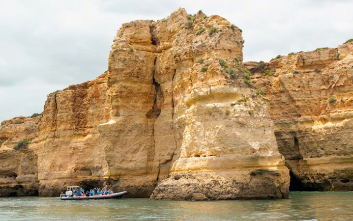 Tourists on RIB boat approaching Benagil Caves in Algarve, Portugal.