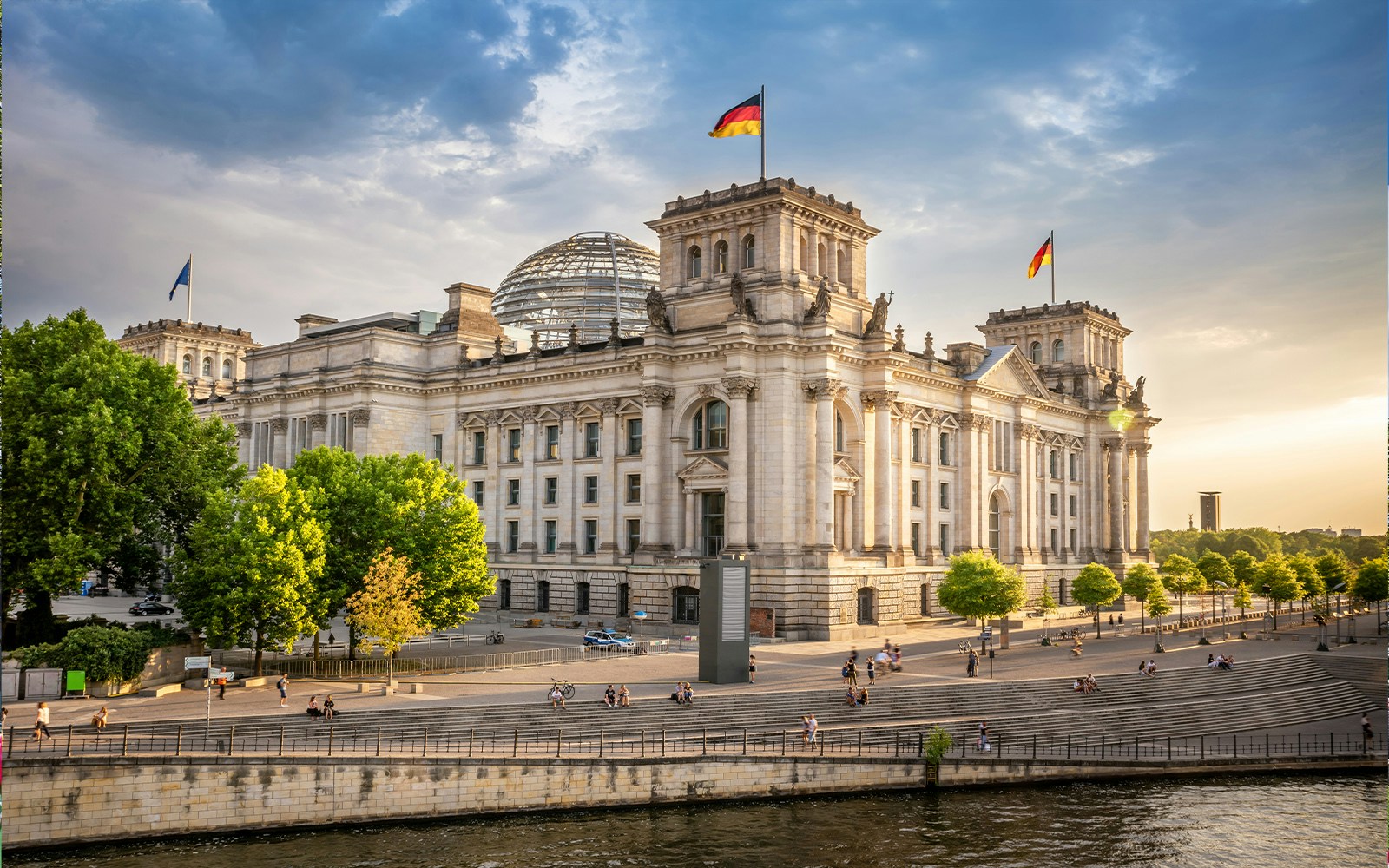 Reichstag building in Berlin's parliament district with people walking nearby.