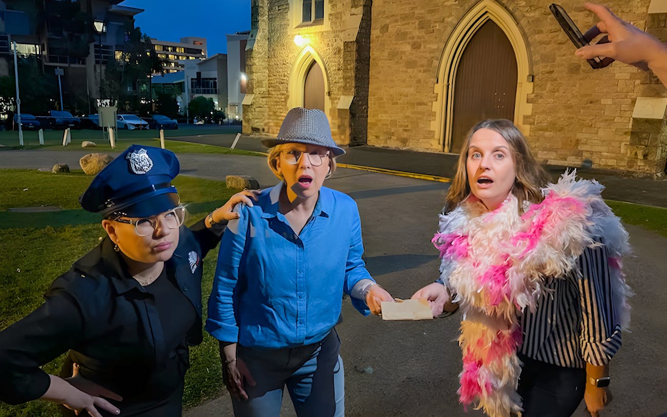 Participants on Fortitude Valley's True Crime Guided Tour acting out a scene near a historic building.