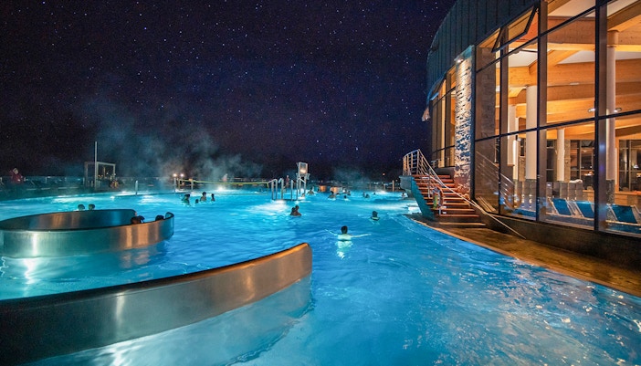 Chocholow Thermal Baths outdoor pool with people relaxing, surrounded by Zakopane's scenic mountain views.