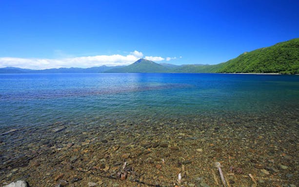 Lake Toya with clear waters and distant mountains, Hokkaido Guided Tour.