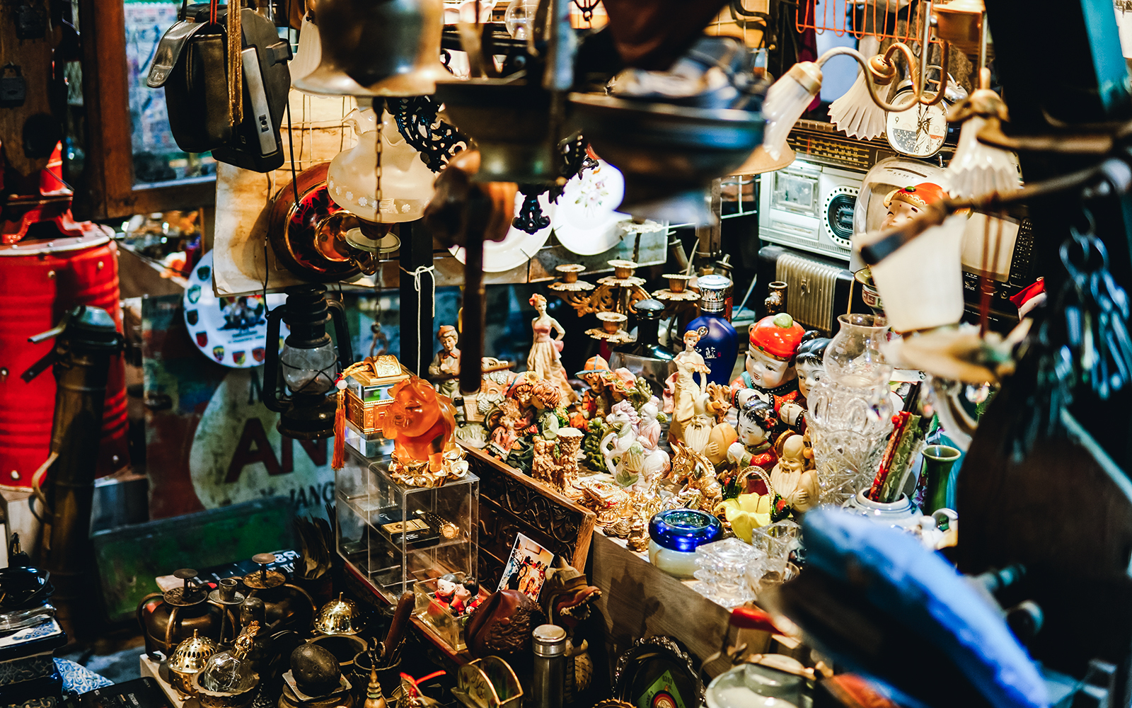 Antique figurines and vintage items displayed in a crowded shop.