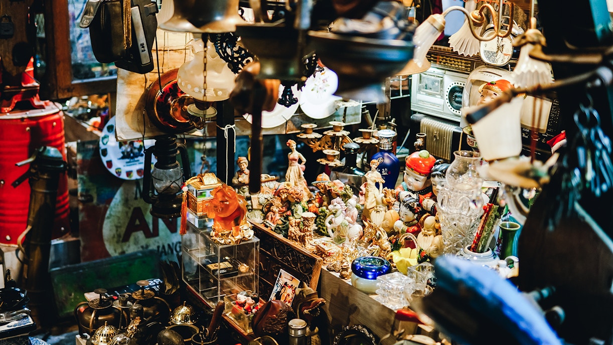 Antique figurines and vintage items displayed in a crowded shop.