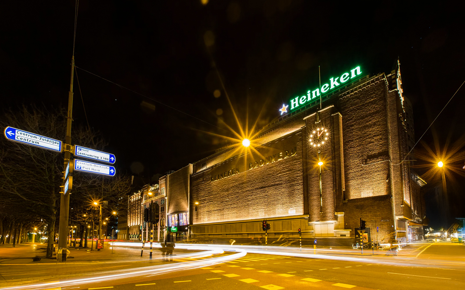 Heineken Experience building illuminated at night in Amsterdam.
