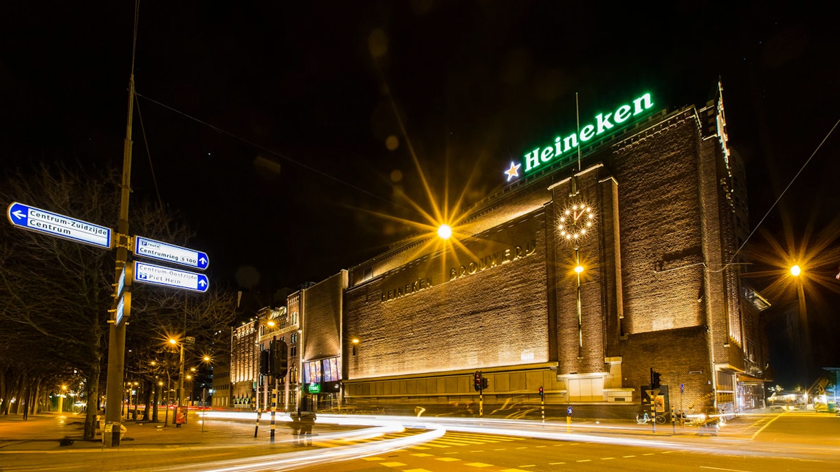 Heineken Experience building illuminated at night in Amsterdam.