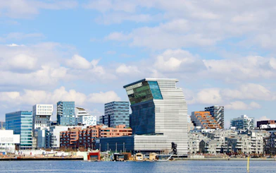Oslo skyline with modern architecture viewed from Oslofjord during sightseeing cruise.