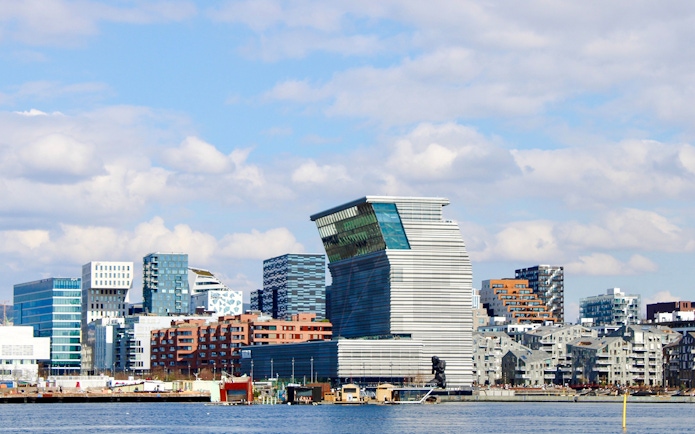 Oslo skyline with modern architecture viewed from Oslofjord during sightseeing cruise.