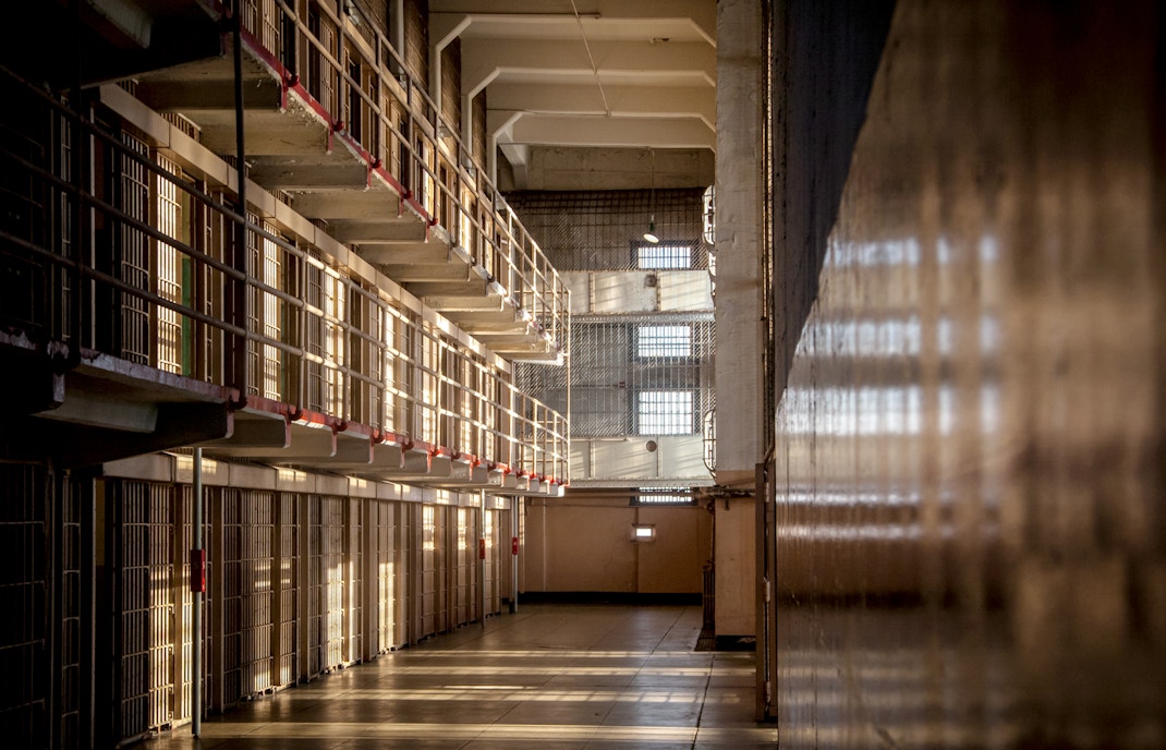 Alcatraz prison cell block interior with sunlight streaming through barred windows, San Francisco tour.