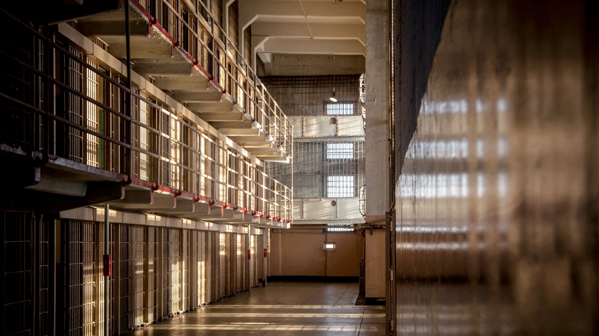 Alcatraz prison cell block interior with sunlight streaming through barred windows, San Francisco tour.