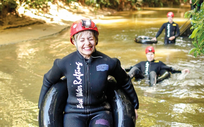 Participants enjoying black water rafting in Waitomo cave stream.